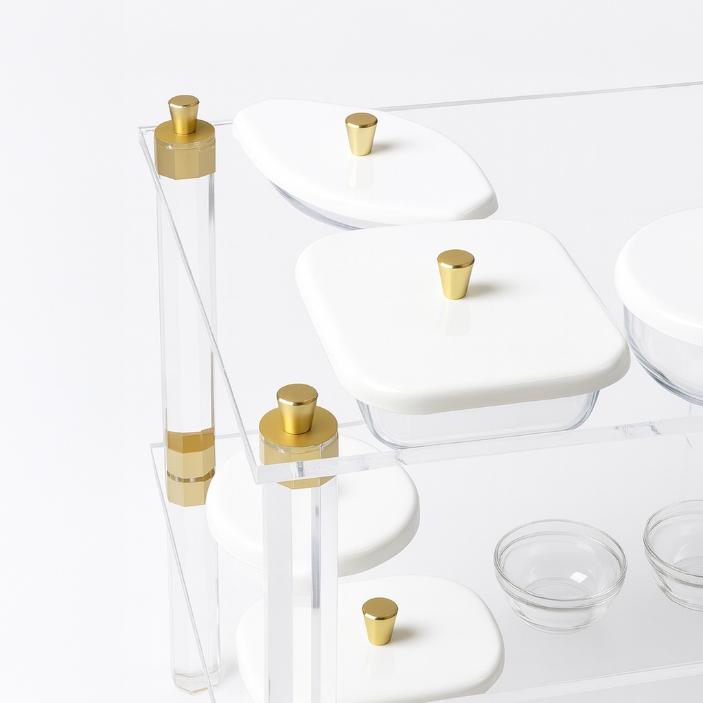 Acrylic trolley-Acrylic serving cart with three shelves and gold accents, white lidded plates.