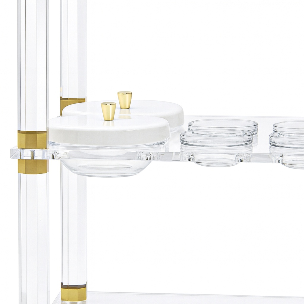 Acrylic trolley-Acrylic serving cart with three shelves and gold accents, white lidded plates.